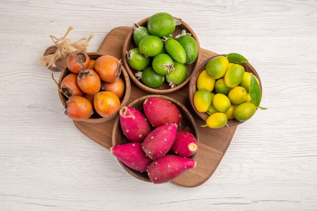 Bovenaanzicht verschillende vruchten feijoas en ander fruit binnen platen op witte achtergrond rijp voedsel exotische kleur