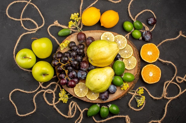 Gratis foto bovenaanzicht verschillende vruchten samenstelling rijp en zacht fruit op donkere achtergrond dieet fruit zacht rijp vers