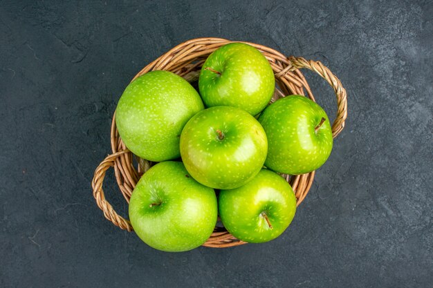 Bovenaanzicht verse appels in rieten mand op donkere oppervlakte vrije ruimte