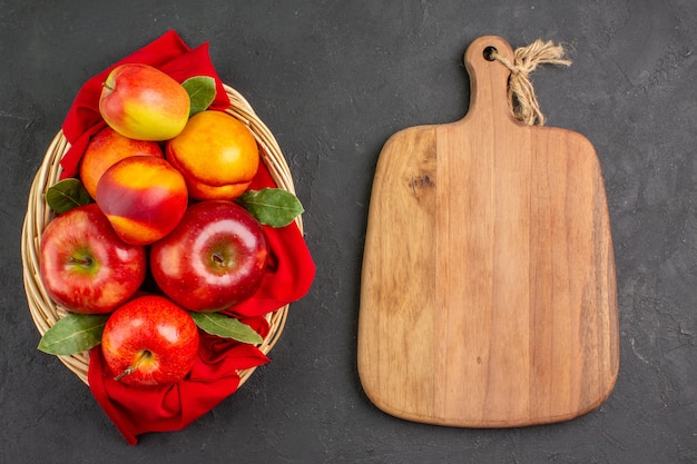 Bovenaanzicht verse appels met perziken in mand op donkere tafel verse fruitboom rijp