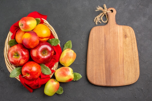 Bovenaanzicht verse appels met perziken in mand op donkergrijs tafelfruit, rijp vers