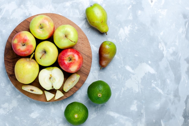 Bovenaanzicht verse appels rijp zacht fruit met mandarijn en peren op licht wit bureau