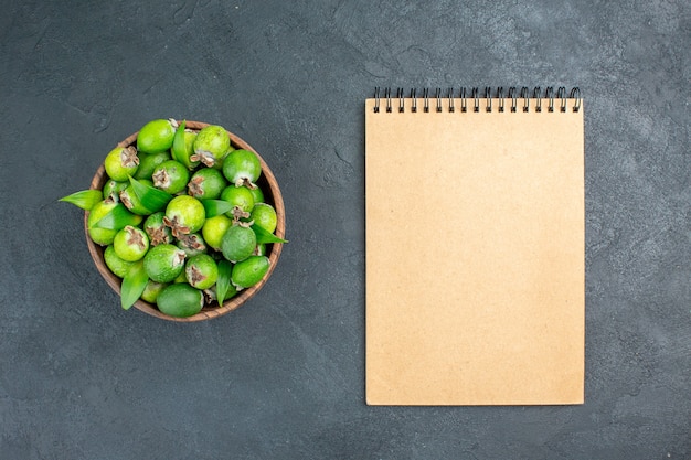 Bovenaanzicht verse feijoas in emmer Kladblok op donkere ondergrond