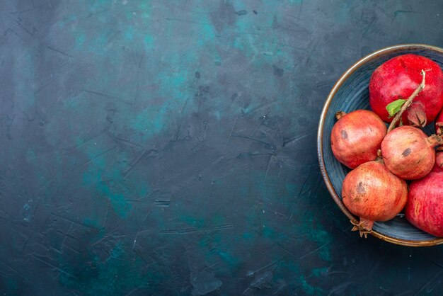 Bovenaanzicht verse granaatappels op donkerblauw bureau