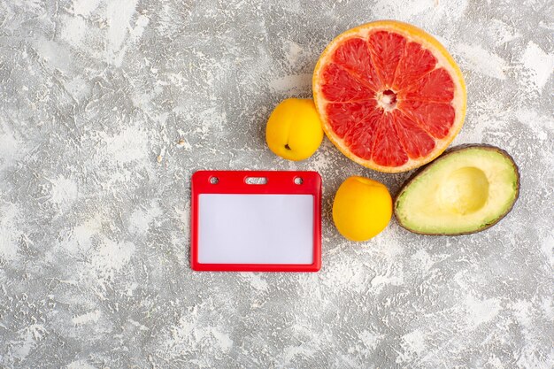 Bovenaanzicht verse grapefruits, zachte en sappige citrusvruchten met avocado op witte ondergrond