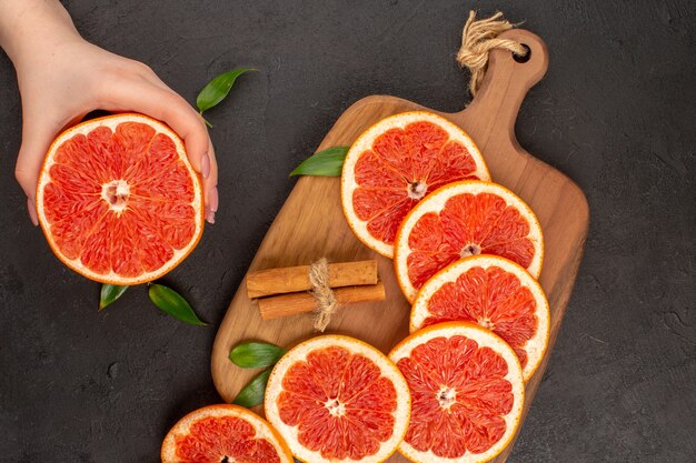 Bovenaanzicht verse grapefruitschijfjes op de donkere achtergrond