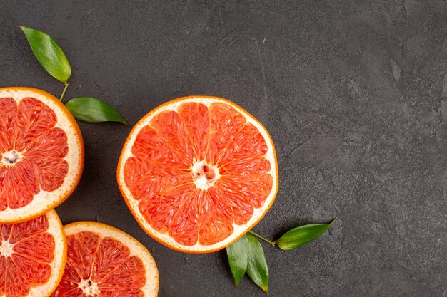 Bovenaanzicht verse grapefruitschijfjes op donkergrijze achtergrond