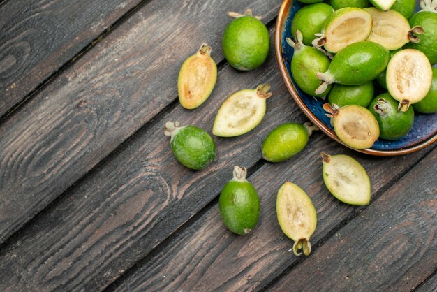 Bovenaanzicht verse groene feijoas binnen plaat op houten rustieke bureau fruit kleurenfoto sap rijp zuur