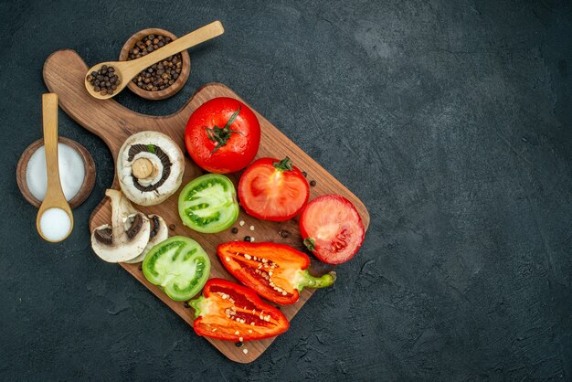 Bovenaanzicht verse groenten champignons rode en groene tomaten paprika op snijplank