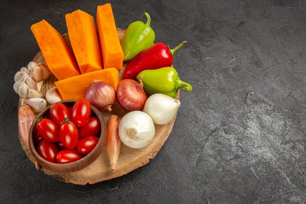 Bovenaanzicht verse groenten met gesneden pompoen op donkergrijze achtergrond rijpe salade kleur vers