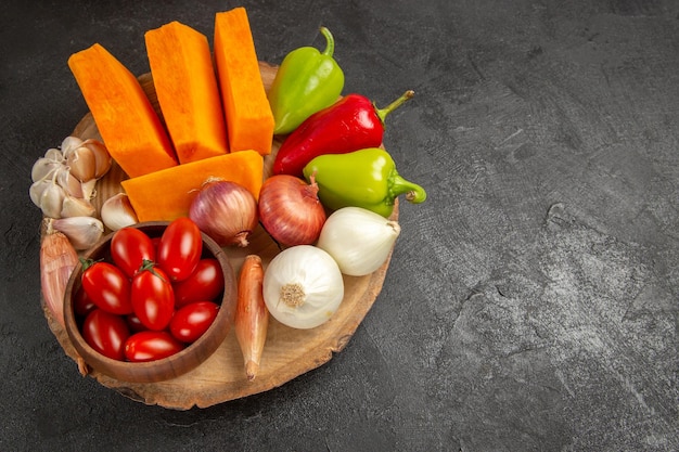 Bovenaanzicht verse groenten met gesneden pompoen op donkergrijze achtergrond rijpe salade kleur vers