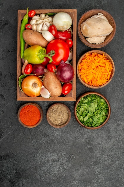 Bovenaanzicht verse groenten met ingrediënten voor de salade op donkere vloer