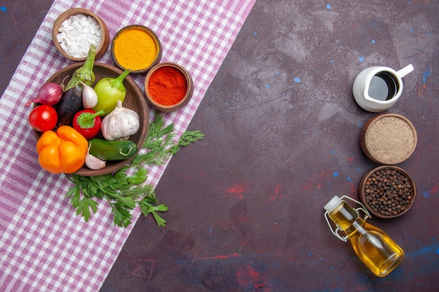 Bovenaanzicht verse groenten met smaakmakers op het donkere oppervlak rijpe salade eten gezondheidslunch