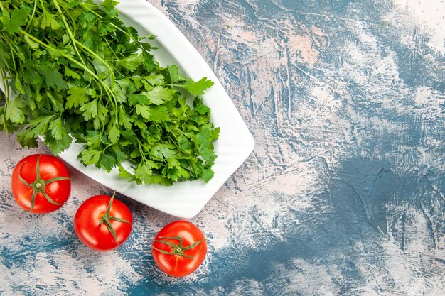 Bovenaanzicht verse groenten met tomaten op lichtblauwe achtergrond