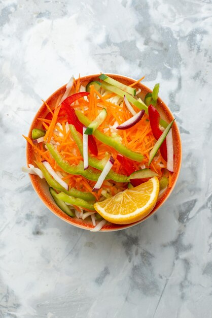 Bovenaanzicht verse groentesalade binnen plaat op wit oppervlak gezondheid voedsel maaltijd dieet horizontaal diner Premium Foto