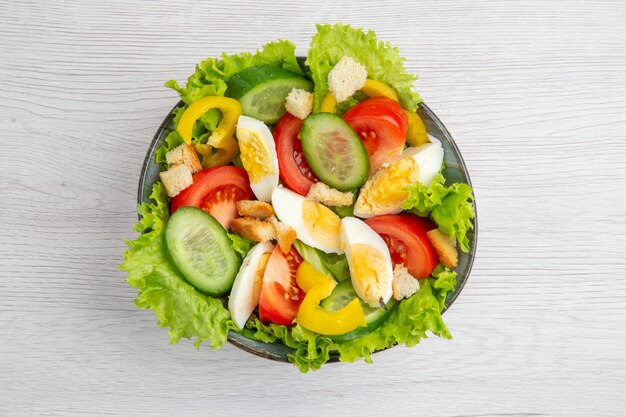 Bovenaanzicht verse groentesalade met eieren op witte achtergrond rijp voedsel ontbijt salade maaltijd lunch kleur