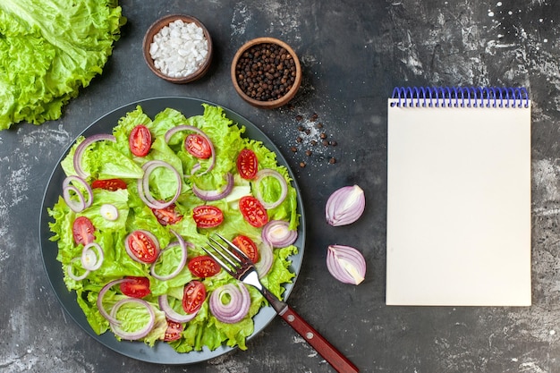 Bovenaanzicht verse groentesalade met groene salade uien en tomaten op grijze achtergrond maaltijdsalade voedsel dieet rijp kleur gezondheid foto