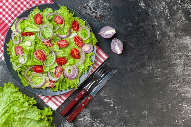 Bovenaanzicht verse groentesalade met uien groene salade en tomaten op grijze achtergrond rijp voedsel gezondheid kleur dieet foto salade maaltijd