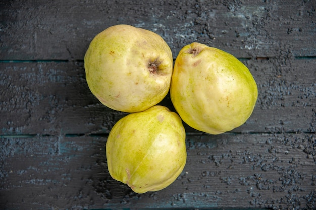 Bovenaanzicht verse kweeperen zacht en zuur fruit op de donkerblauwe bureau rijpe foetus verse boom zure plant