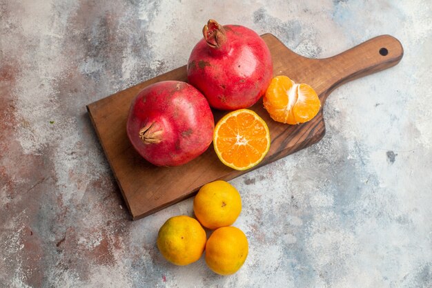 Bovenaanzicht verse mandarijnen met granaatappels op lichte achtergrond