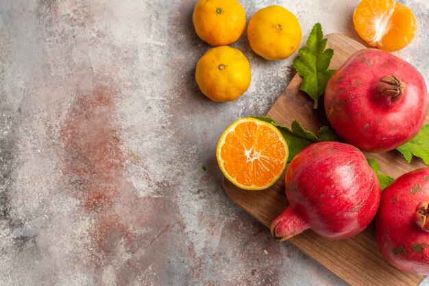 Bovenaanzicht verse mandarijnen met rode granaatappels op lichte achtergrond