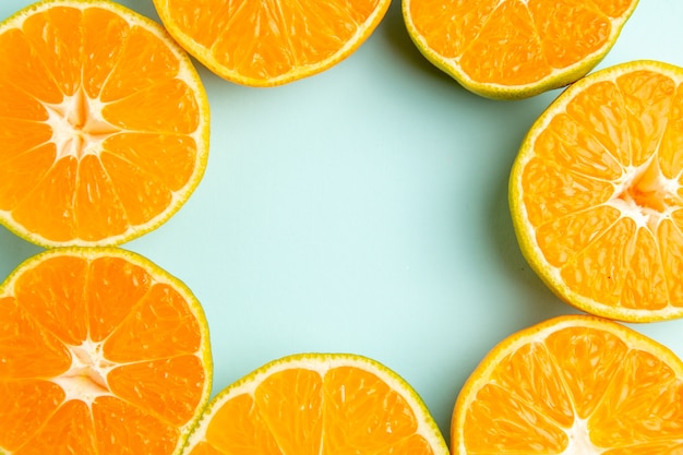 Bovenaanzicht verse mandarijnplakken bekleed op de lichtblauwe achtergrond