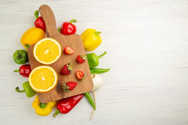 Bovenaanzicht verse paprika met gesneden sinaasappel op witte achtergrond salade rijpe kleurenfoto gezond leven dieet vrije ruimte