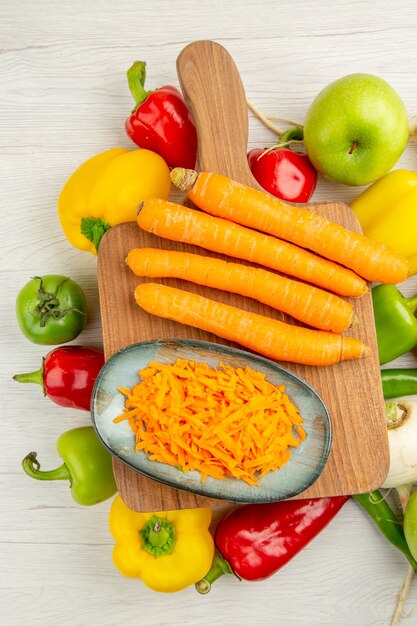 Bovenaanzicht verse paprika met wortel en appels op witte achtergrond foto salade gezond leven rijp kleur dieet