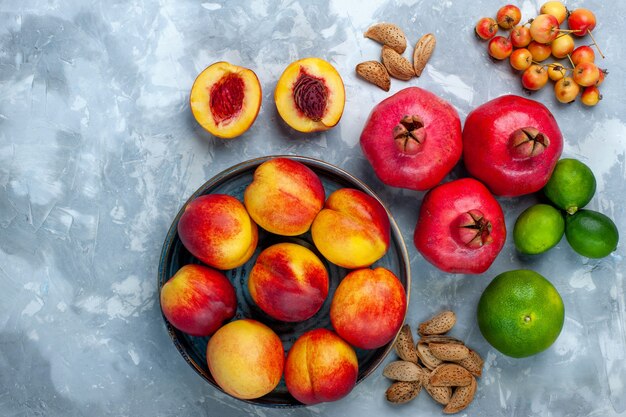 Bovenaanzicht verse perziken heerlijk zomerfruit met mandarijnen en citroen op lichtwit bureau