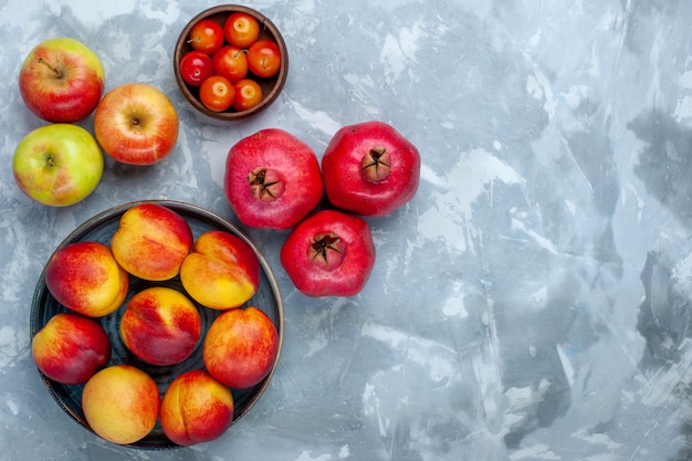 Bovenaanzicht verse perziken heerlijke zomerfruit met appels op lichtwit bureau Gratis Foto