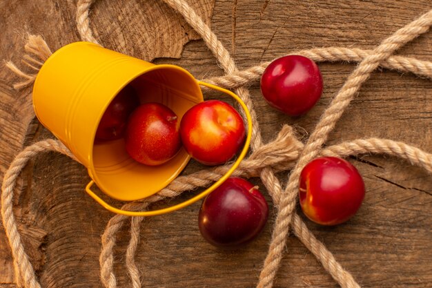 Bovenaanzicht verse pruimen met touwen op het houten bureau vruchtensap vitamine food mellow