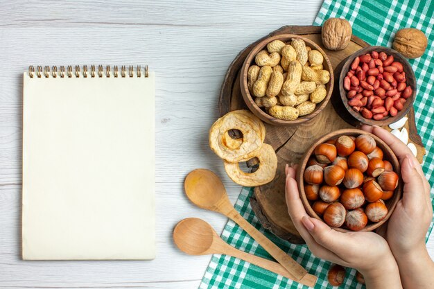 Bovenaanzicht verse rauwe hazelnoten met pinda's op witte tafel