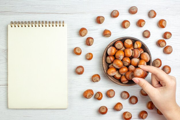 Bovenaanzicht verse rauwe hazelnoten op witte bureaunoot filmplanten eten walnoot snack