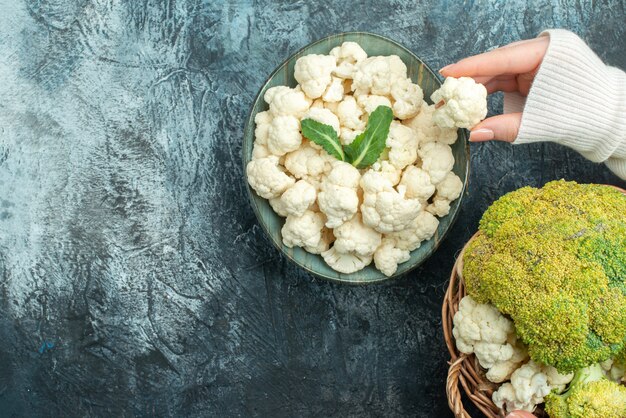 Bovenaanzicht verse rijpe bloemkool in mand op de lichtgrijze tafel