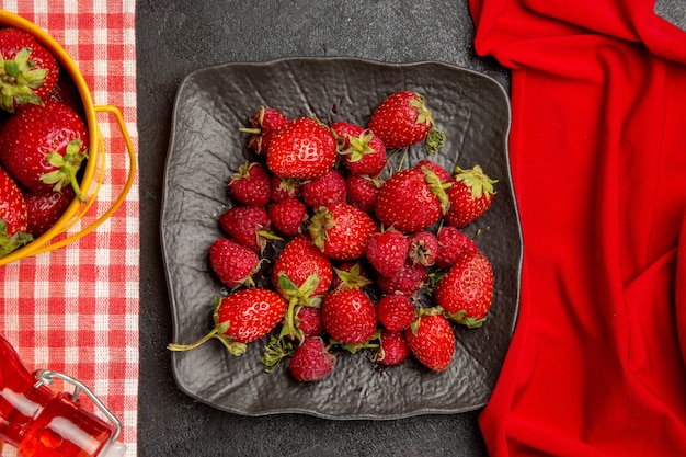 Bovenaanzicht verse rode aardbeien op de donkere tafel kleur fruit frambozen bes