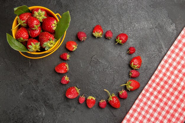 Bovenaanzicht verse rode aardbeien op een donkere tafel bes kleur fruit framboos