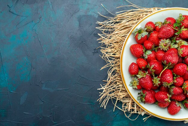 Bovenaanzicht verse rode aardbeien zachte vruchten bessen binnen plaat op donkerblauwe achtergrond bessen fruit zachte zomer voedsel vitamine