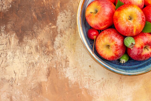 Bovenaanzicht verse rode appels met feijoa's in bakje