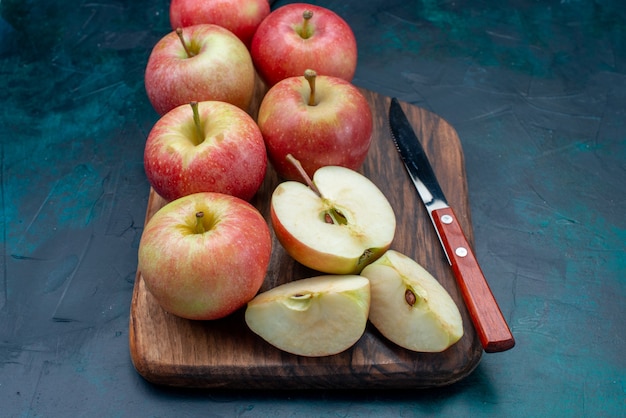 Bovenaanzicht verse rode appels sappig en zacht met bruin bureau op donkerblauw oppervlak rijp fruit vers zacht