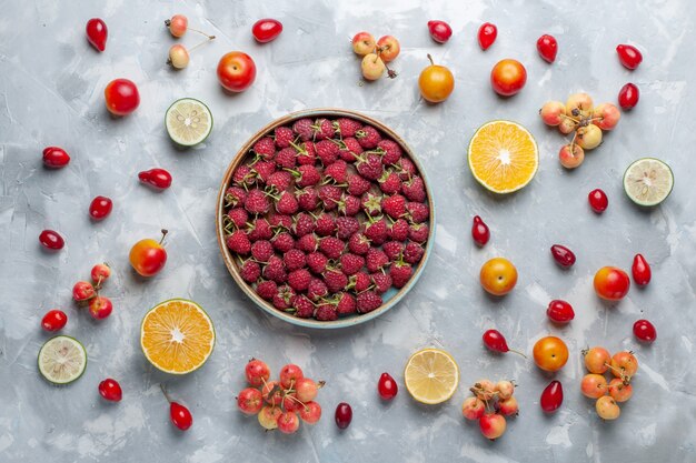 Bovenaanzicht verse rode frambozen met citroen en kersen op wit bureau fruit berry vitamine zomer zacht