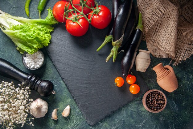 bovenaanzicht verse rode tomaten met aubergines op donkere ondergrond diner salade rijp kweek maaltijd foto voedselkleuren