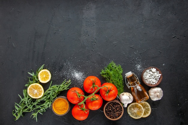 Gratis foto bovenaanzicht verse tomaten met schijfjes citroen op donkere tafel