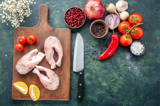 Bovenaanzicht verse vis plakjes met tomaten en citroen op donkere achtergrond zeevruchten oceaan vlees zeewater peper schotel voedsel