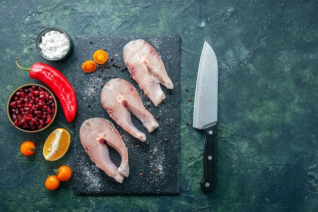 Bovenaanzicht verse vis plakjes op de donkere achtergrond zeevruchten oceaan vlees zee maaltijd schotel salade water peper eten