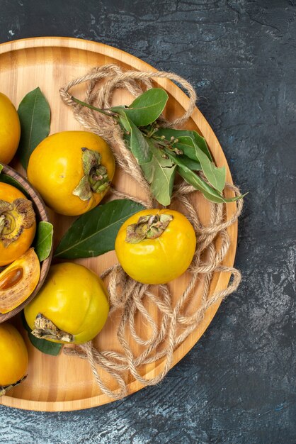 Bovenaanzicht verse zoete kaki op een donkere tafel smaak rijp fruit