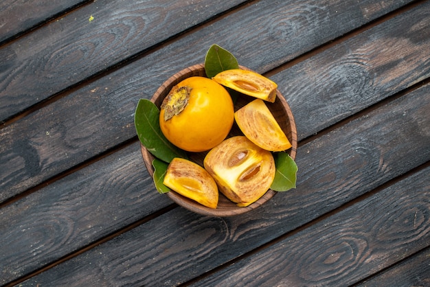 Gratis foto bovenaanzicht verse zoete kaki op een houten rustieke tafel, zacht fruit gezondheid