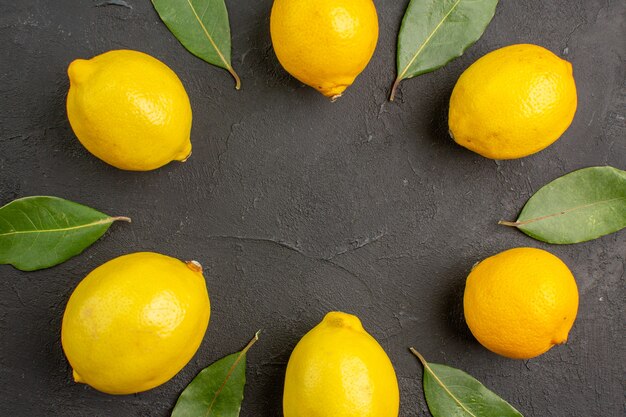 Bovenaanzicht verse zure citroenen bekleed op donkere tafel, fruit citrus gele limoen