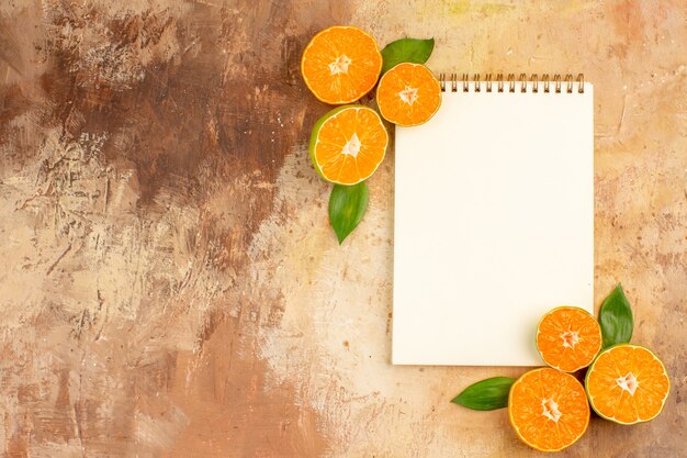 Bovenaanzicht verse zure mandarijnen met notitieblok