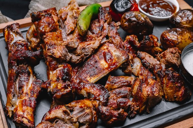 Bovenaanzicht vlees kebab met aardappelen en gegrilde groenten met saus op het bord