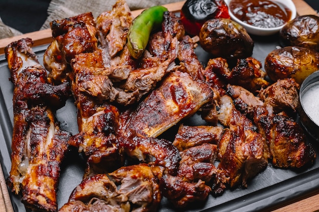 Bovenaanzicht vlees kebab met aardappelen en gegrilde groenten met saus op het bord